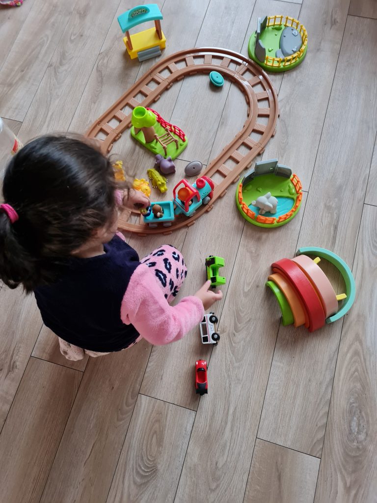 kind speelt met kleurrijk houten speelgoed.